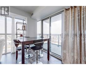 A dining room with a table and chairs and a view of the city.