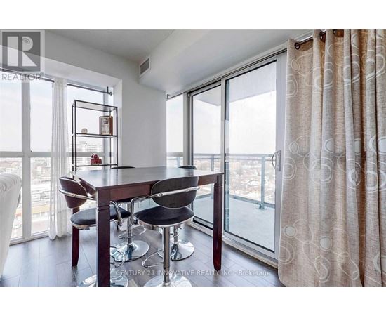 A dining room with a table and chairs and a view of the city.