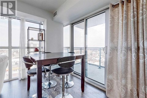 A dining room with a table and chairs and a view of the city.