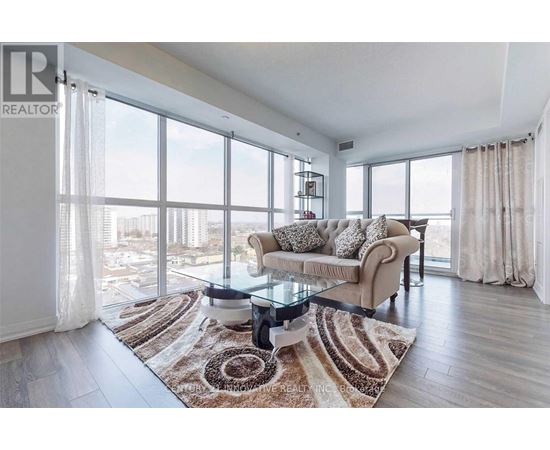 A living room with a glass table and a couch with a view of the city.