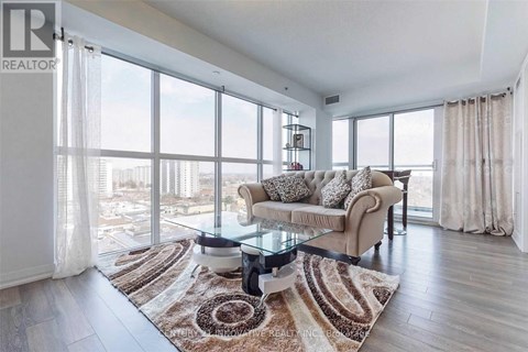 A living room with a glass table and a couch with a view of the city.