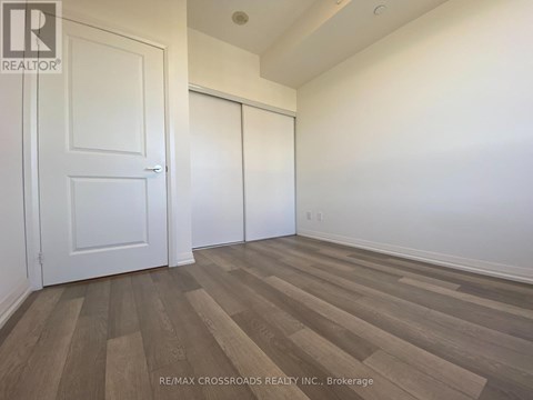 A room with a white door and a white wall with a wooden floor.