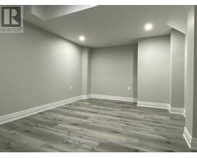 A room with wooden flooring and white walls.