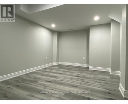 A room with wooden flooring and white walls.