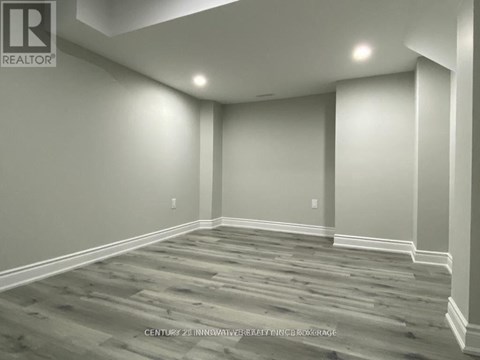 A room with wooden flooring and white walls.