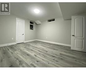 A room with wooden flooring and two white doors.