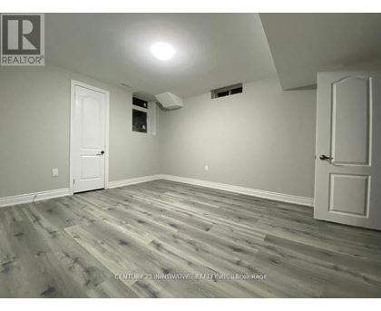 A room with wooden flooring and two white doors.