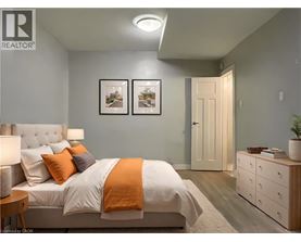 A bedroom with a bed, nightstand, and two pictures on the wall.