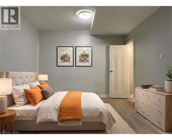A bedroom with a bed, nightstand, and two pictures on the wall.