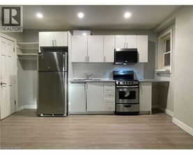 A kitchen with a refrigerator, oven, and microwave.