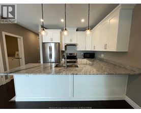 A kitchen with a granite countertop and white cabinets.