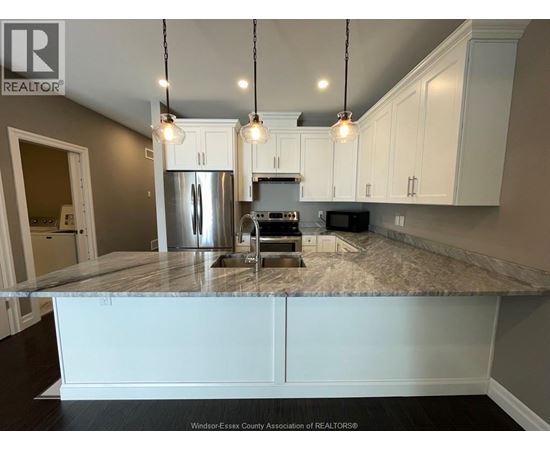 A kitchen with a granite countertop and white cabinets.