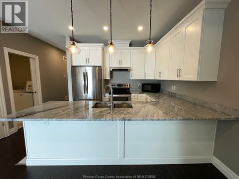 A kitchen with a granite countertop and white cabinets.
