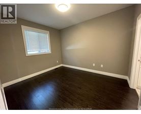 A room with a window and wooden flooring.