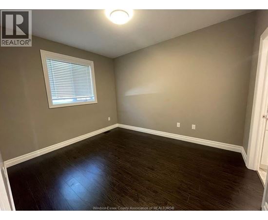 A room with a window and wooden flooring.