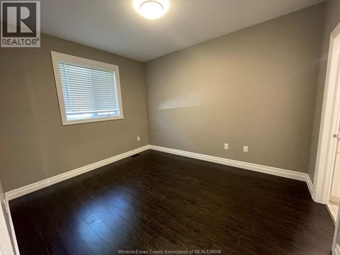 A room with a window and wooden flooring.