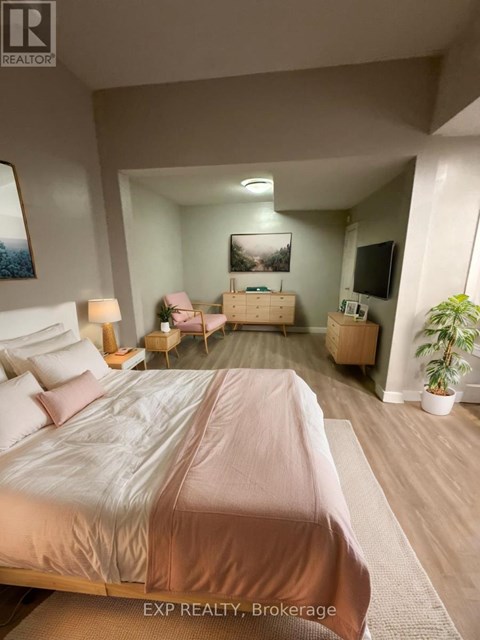 A bedroom with a large bed and a television in the corner.
