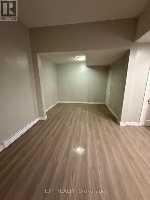A room with wooden flooring and white walls.