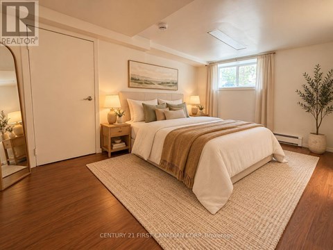 A bedroom with a large bed and a painting on the wall.