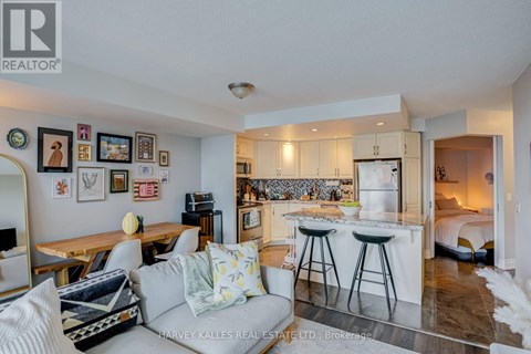 A well-lit, modern kitchen and living room with a dining table and chairs.