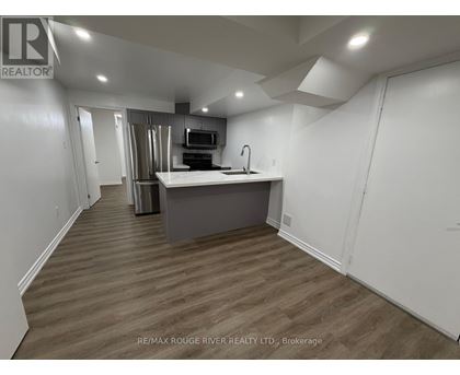 A kitchen area with a sink and a microwave.