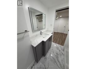 A bathroom with a marble floor and a white sink.