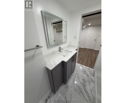 A bathroom with a marble floor and a white sink.