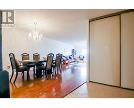 A dining room with a table and chairs.