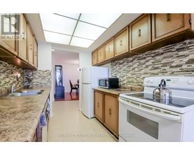 A kitchen with a white stove top oven and a white refrigerator.