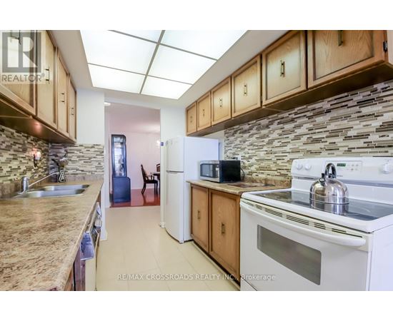 A kitchen with a white stove top oven and a white refrigerator.