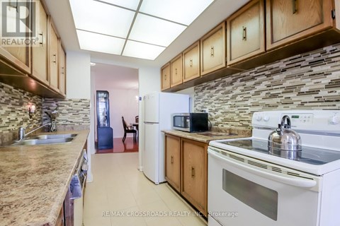 A kitchen with a white stove top oven and a white refrigerator.