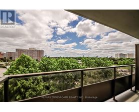 A balcony with a view of a cityscape and trees.