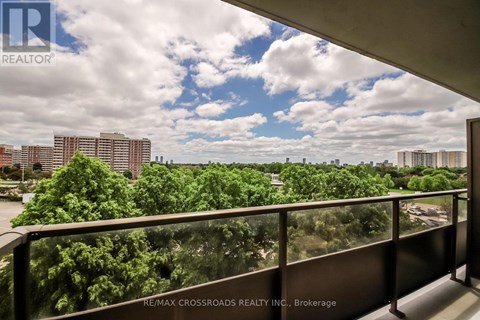 A balcony with a view of a cityscape and trees.