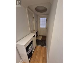 A hallway with a white door and a white cabinet.