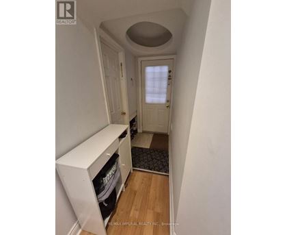 A hallway with a white door and a white cabinet.