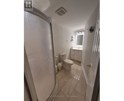 A white bathroom with a toilet, sink, and shower.