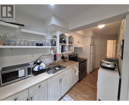 A kitchen with white cabinets and a black counter top.