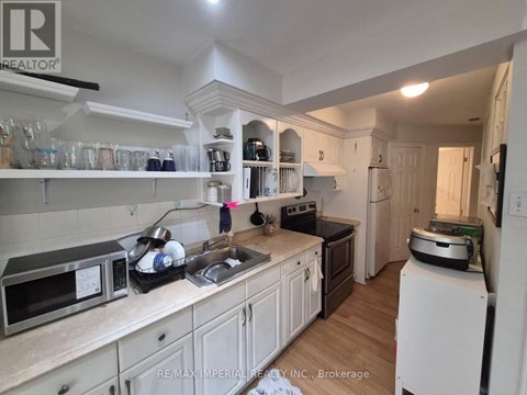 A kitchen with white cabinets and a black counter top.