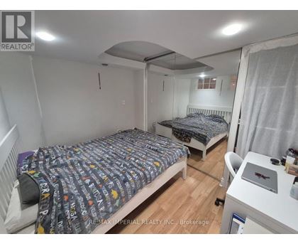 A bedroom with two beds and a desk with a laptop on it.