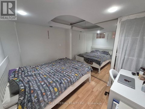 A bedroom with two beds and a desk with a laptop on it.