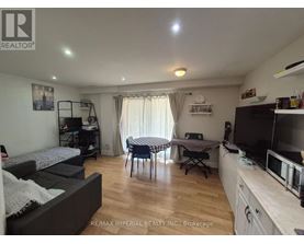 A living room with a couch, a dining table, and a television.