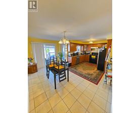 A kitchen with a dining table and chairs.