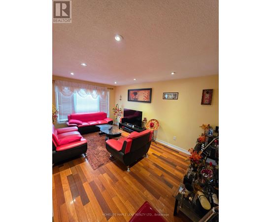 A living room with a red couch and a wooden floor.