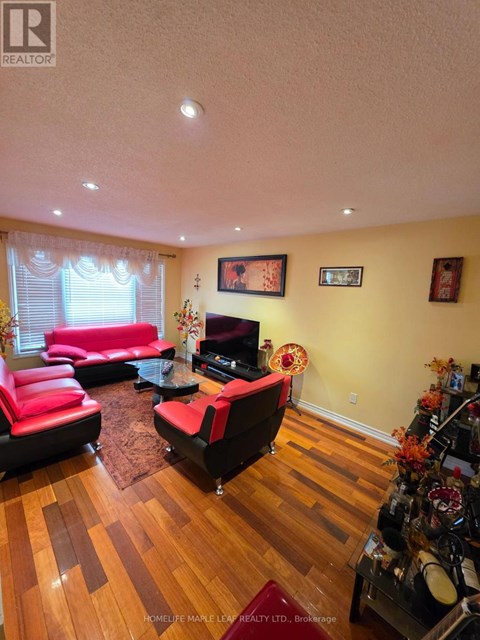 A living room with a red couch and a wooden floor.