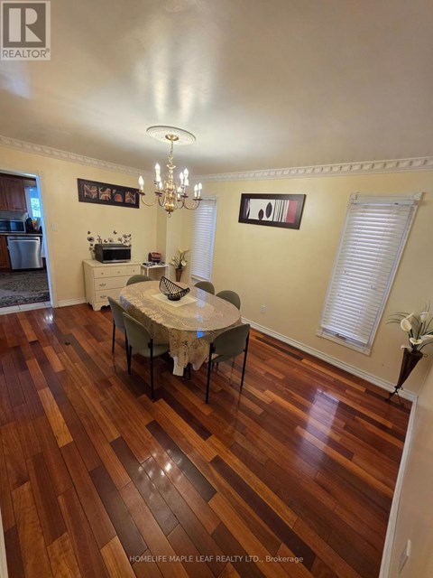 A dining room with a table set for two and a chandelier.