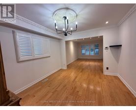 A well-lit room with wooden floors and a chandelier.