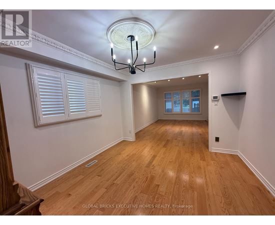 A well-lit room with wooden floors and a chandelier.