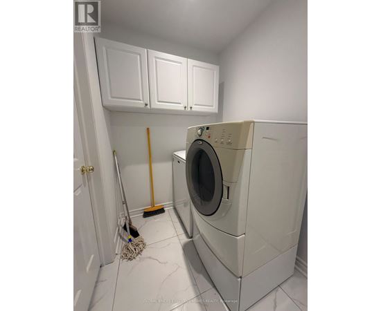 A white washing machine in a laundry room.