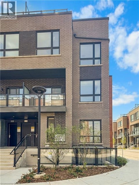 A modern brick building with a black railing in front.