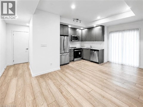 A spacious kitchen with wooden flooring and modern appliances.